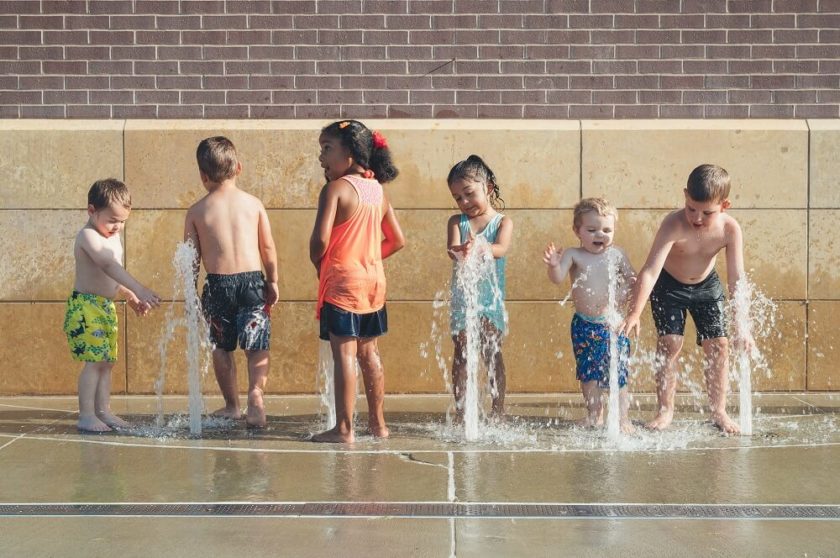 Kinder spielen im Wasser eines Springbrunnens